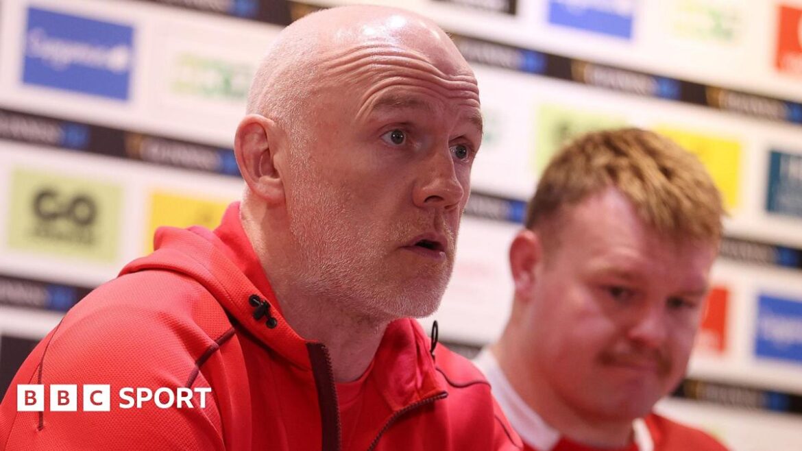 Wales head coach Steve Tandy speaks at a media conference with captain Dewi Lake in the background
