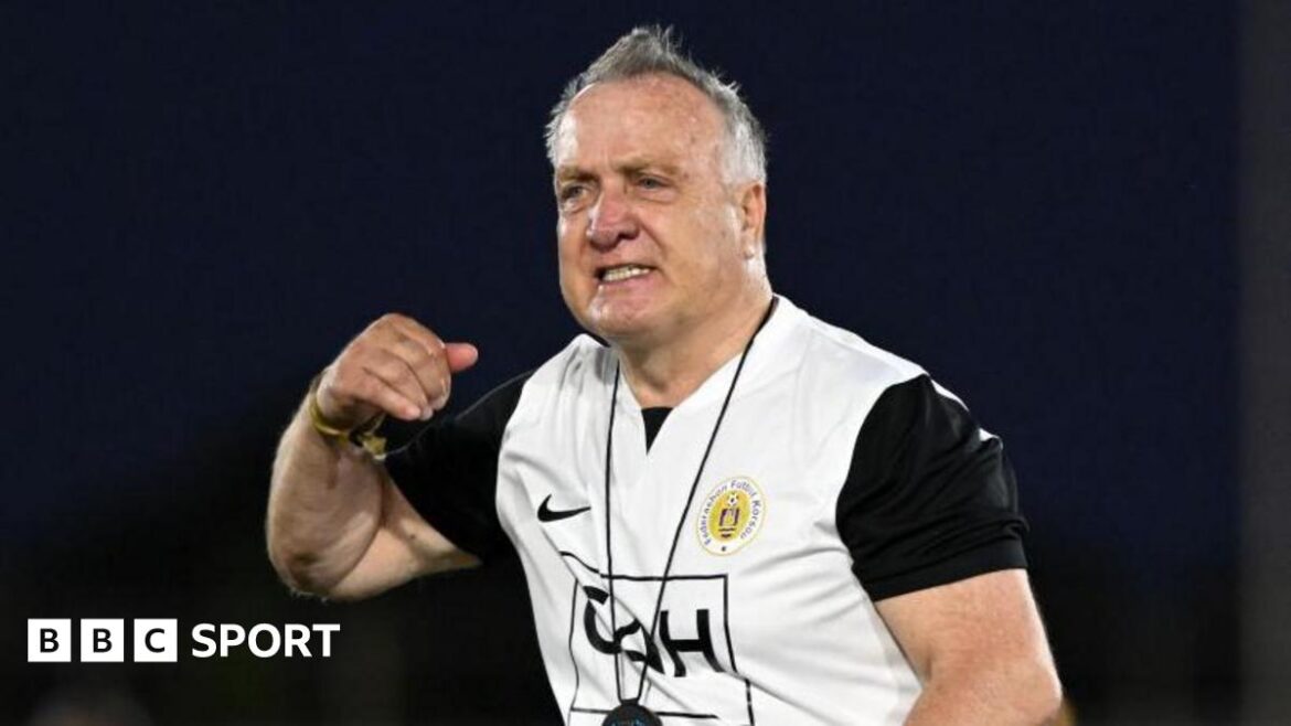 Dick Advocaat, wearing a white and black Curacao training top, gestures with his right arm
