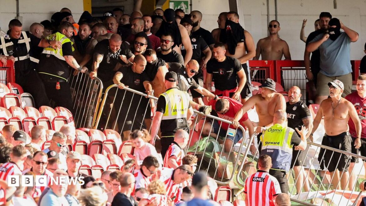 Shows football fans in a stadium separated by barriers