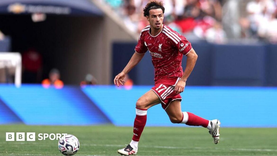 Curtis Jones running with the ball in Liverpool's 2026-27 red home kit