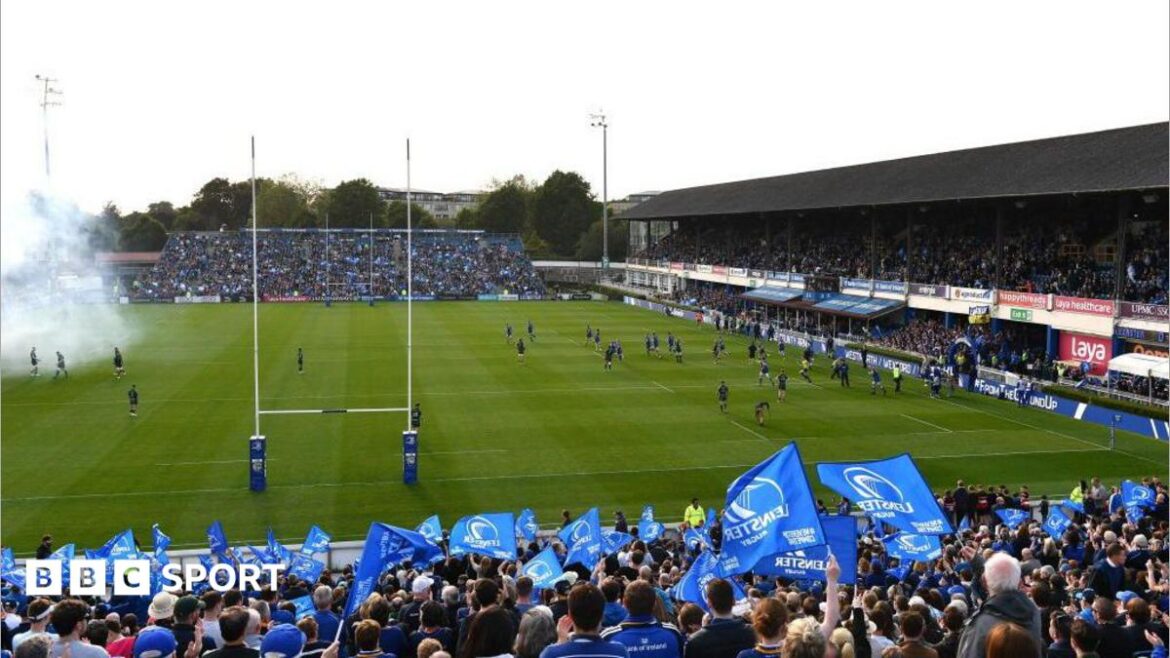 Leinster fans wave blue flags as smoke from fireworks drifts across their home ground ahead of a game against Connacht in 2024
